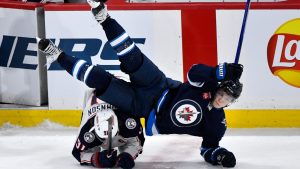 Columbus Blue Jackets' Kent Johnson (91) trips up Winnipeg Jets' Vladislav Namestnikov (7) during third period NHL hockey action in Winnipeg, Sunday, Dec. 8, 2024. (Fred Greenslade/THE CANADIAN PRESS)