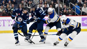 Winnipeg Jets' Kyle Connor (81) and Mark Scheifele (55) battle for the puck with St. Louis Blues' Radek Faksa (12) and Pierre-Olivier Joseph (77) during the second period of their NHL hockey game in Winnipeg, Tuesday December 3, 2024. (Fred Greenslade/CP)