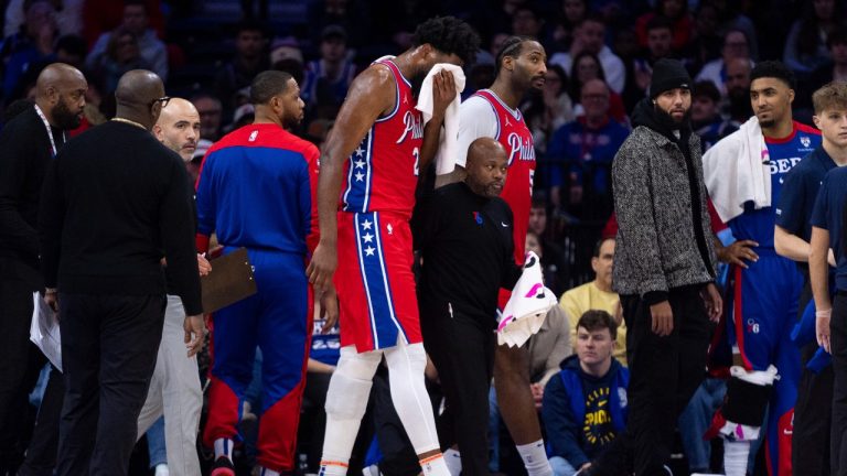 Philadelphia 76ers' Joel Embiid, centre, gets helped off the court after getting hit in the face during the first half of an NBA basketball game against the Indiana Pacers, Friday, Dec. 13, 2024, in Philadelphia. (Chris Szagola/AP)