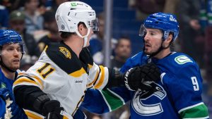 Boston Bruins' Trent Frederic (11) and Vancouver Canucks' J.T. Miller (9) exchange words during the second period of an NHL hockey game in Vancouver, B.C., Saturday, Dec. 14, 2024. (Ethan Cairns/CP)