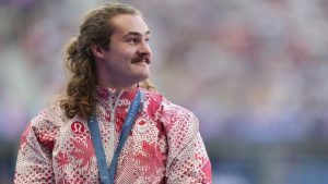 Ethan Katzberg, of Nanaimo, B.C., receives his gold medal in the men's hammer throw event at the 2024 Summer Olympics, in Saint-Denis, France, Monday, Aug. 5, 2024. (Christinne Muschi/CP)
