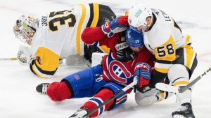 Pittsburgh Penguins' Kris Letang (58) grabs Montreal Canadiens' Josh Anderson (17) after he collides with Penguins' goaltender Tristan Jarry (35) during second period NHL hockey action in Montreal, Thursday, Dec. 12, 2024. (Christinne Muschi/CP)