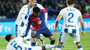 Barcelona's Lamine Yamal, centre, and Leganes' Renato Tapia, bottom challenge for the ball during the Spanish La Liga soccer match between Barcelona and Leganes at the Lluis Companys Olympic Stadium in Barcelona, Spain, Sunday, Dec. 15, 2024. (Joan Monfort/AP)