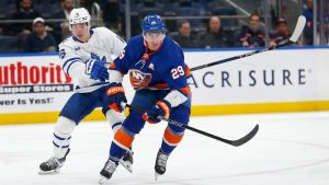 Toronto Maple Leafs forward Mitchell Marner and New York Islanders centre Brock Nelson (29) battle for the puck during the third period of an NHL hockey game Monday, Dec. 11, 2023, in Elmont, New York. (John Munson/AP)