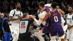 Dallas Mavericks forward Naji Marshall, left, and Phoenix Suns center Jusuf Nurkic have to be separated after fighting during the second half of an NBA basketball game, Friday, Dec. 27, 2024, in Phoenix. Dallas won 98-89. (Rick Scuteri/AP)