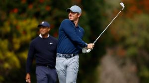 Rory McIlroy, right, hits from the fourth tee as Tiger Woods watches during the first round of the Genesis Invitational golf tournament at Riviera Country Club, Thursday, Feb. 16, 2023, in the Pacific Palisades area of Los Angeles. (Ryan Kang/AP)