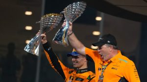 McLaren driver Lando Norris of Britain and McLaren team principal Zak Brown stand on the podium after the Formula One Abu Dhabi Grand Prix at the Yas Marina Circuit in Abu Dhabi, UAE, Sunday, Dec. 8, 2024. (Darko Bandic/AP)