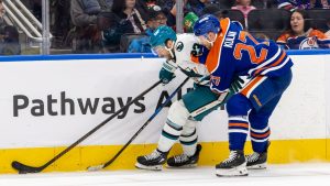 San Jose Sharks' Barclay Goodrow (23) skates with the puck against Edmonton Oilers' Brett Kulak (27) during first period NHL action in Edmonton, Saturday, Dec. 21, 2024. (Timothy Matwey/THE CANADIAN PRESS)