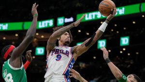 Philadelphia 76ers' Kelly Oubre Jr. (9) shoots against Boston Celtics' Neemias Queta and Jayson Tatum during the second half of an NBA basketball game, Wednesday, Dec. 25, 2024, in Boston (Michael Dwyer/AP Photo)