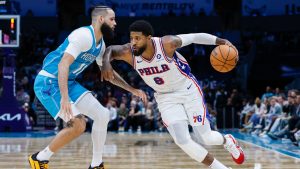 Philadelphia 76ers forward Paul George (8) drives against Charlotte Hornets forward Cody Martin, left, during the second half of an NBA basketball game in Charlotte, N.C., Monday, Dec. 16, 2024. (Nell Redmond/AP)