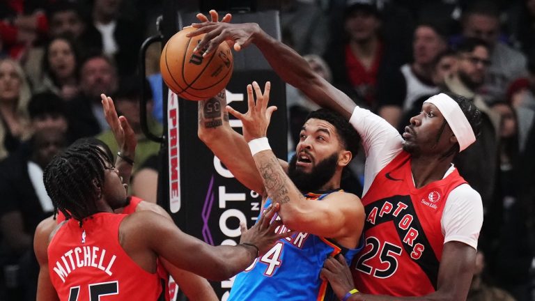 Oklahoma City Thunder's Kenrich Williams (centre) battles for the ball with Toronto Raptors' Davion Mitchell (45) and Chris Boucher (25) during first half NBA basketball action in Toronto on Thursday, December 5, 2024. (Nathan Denette/CP)