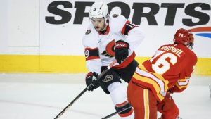 Ottawa Senators' Drake Batherson, left, steals the puck from Calgary Flames' Martin Pospisil during first period NHL hockey action in Calgary on Thursday, Dec. 19, 2024. (Jeff McIntosh/THE CANADIAN PRESS)