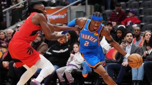 Oklahoma City Thunder's Shai Gilgeous-Alexander (right) drives past Toronto Raptors' Jonathan Mogbo during second half NBA basketball action in Toronto on Thursday, December 5, 2024. (Nathan Denette/THE CANADIAN PRESS)