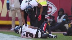 Houston Texans wide receiver Tank Dell, grabs his knee while being checked on by teammate Jared Wayne after catching a touchdown pass during the second half of an NFL football game. (Charlie Riedel/AP)