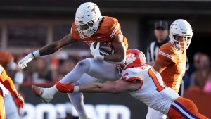 Texas running back Jaydon Blue (23) tries to break a tackle by Clemson linebacker Wade Woodaz (17) during the first half in the first round of the College Football Playoff, Saturday, Dec. 21, 2024, in Austin, Texas. (Eric Gay/AP Photo)