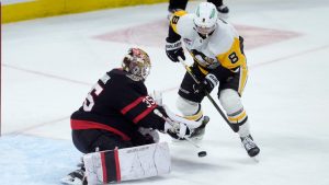 Pittsburgh Penguins' Michael Bunting (8) pressures Ottawa Senators goaltender Linus Ullmark during second period NHL action in Ottawa, Saturday, Dec. 14, 2024. (Adrian Wyld/CP)