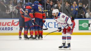 New York Rangers centre Vincent Trocheck, right, reacts as St. Louis Blues players, back left, celebrate after a goal by left wing Pavel Buchnevich as during the first period of an NHL hockey game Sunday, Dec. 15, 2024, in St. Louis. (AP Photo/Jeff Le)