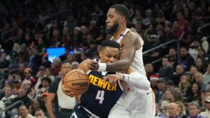 Denver Nuggets guard Russell Westbrook (4) drives on Phoenix Suns forward Royce O'Neale during the first half of an NBA basketball game, Wednesday, Dec. 25, 2024, in Phoenix. (Rick Scuteri/AP Photo)