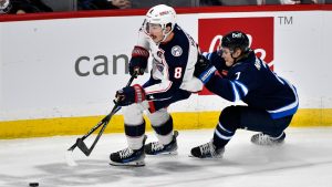 Columbus Blue Jackets' Zach Werenski (8) is chased by Winnipeg Jets' Vladislav Namestnikov (7) during first period NHL hockey action in Winnipeg, Sunday Dec. 8, 2024. (Fred Greenslade/CP)