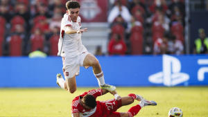 Toronto FC midfielder Alonso Coello leaps over Chicago Fire defender Allan Arigoni during first half MLS action in Toronto. (CP/Cole Burston)