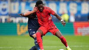 Bochum's Felix Passlack holds Bayern's Alphonso Davies during the German Bundesliga soccer match between VfL Bochum and Bayern Munich in Bochum, Germany, Sunday, Oct. 27, 2024. (Martin Meissner/AP)