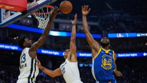 From left, Memphis Grizzlies forward Jaren Jackson Jr. (13), guard Desmond Bane and Golden State Warriors forward Andrew Wiggins compete for possession of the ball during the first half of an NBA basketball game. (Godofredo A. Vásquez/AP)