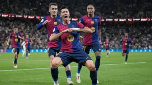 Barcelona's Robert Lewandowski, centre, celebrates after scoring his side's second goal during the Spain Super Cup final soccer match between Real Madrid and Barcelona at King Abdullah Stadium in Jeddah, Saudi Arabia, Sunday, Jan. 12, 2025. (Altaf Qadri/AP)