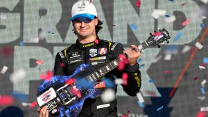 Colton Herta holds his guitar trophy after winning an IndyCar auto race Sunday, Sept. 15, 2024, at Nashville Superspeedway. (AP Photo/Mark Humphrey)