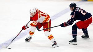 Calgary Flames forward Jonathan Huberdeau controls the puck in front of Columbus Blue Jackets' Sean Monahan during a game in Columbus, Ohio, Friday, Nov. 29, 2024. (AP/Paul Vernon)