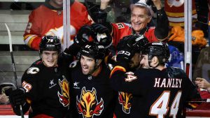 Calgary Flames' Nazem Kadri (91) celebrates his goal with teammates during the third period of an NHL hockey game against the Vancouver Canucks in Calgary on Tuesday, Dec. 31, 2024. (Jeff McIntosh/CP)