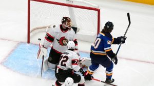 St. Louis Blues' Brandon Saad (20) scores past Ottawa Senators goaltender Anton Forsberg (31) and Thomas Chabot (72) during the first period of an NHL hockey game Friday, Jan. 3, 2025, in St. Louis. (AP Photo/Jeff Roberson)