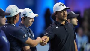 Xander Schauffele of New York Golf Club bumps fists with teammate Rickie Fowler, second left, as teammate Matt Fitzpatrick, third left, looks on, at the start of the inaugural match of the TGL indoor golf league, Tuesday, Jan. 7, 2025, in Palm Beach Gardens, Fla. (AP Photo/Rebecca Blackwell)