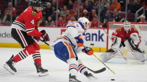 Chicago Blackhawks defenceman Seth Jones (4), left, chases Edmonton Oilers centre Connor McDavid (97) as he loses control of the puck during the first period of an NHL hockey game Saturday, Jan. 11, 2025, in Chicago. (Erin Hooley/AP)