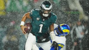 Los Angeles Rams defensive tackle Neville Gallimore tackles Philadelphia Eagles quarterback Jalen Hurts during the second half of their NFC divisional playoff game Sunday, Jan. 19, 2025, in Philadelphia. (AP Photo/Derik Hamilton)