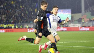 Venezia's Alessio Zerbin, left, and Verona's Tomas Suslov challenge for the ball during the Serie A soccer match between Venezia and Hellas Verona at the Pier Luigi Penzo Stadium in Venice, Italy, Monday, Jan. 27, 2025. (Paola Garbuio/LaPresse via AP)