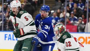 Toronto Maple Leafs' Auston Matthews (34) tries to tip the puck in front of Minnesota Wild goaltender Filip Gustavsson (32) as Jake Middleton (5) defends during second period NHL hockey action in Toronto on Wednesday, January 29, 2025. (Frank Gunn/CP)