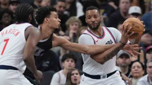 San Antonio Spurs centre Victor Wembanyama, center, reaches in on LA Clippers guard Norman Powell, right, during the second half of an NBA basketball game in San Antonio, Wednesday, Jan. 29, 2025. (Eric Gay/AP)