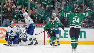 Dallas Stars left wing Jason Robertson (21) turns to celebrate after scoring a goal with teammate Roope Hintz (24) against Vancouver Canucks defenders Tyler Myers (57), Dakota Joshua (81), Filip Hronek (17) and goaltender Thatcher Demko (35) during the second period of an NHL hockey game Friday, Jan. 31, 2025, in Dallas. (LM Otero/AP)