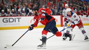 Washington Capitals right wing Tom Wilson, left, takes a shot as New York Rangers left wing Artemi Panarin (10) looks on during the first period of an NHL hockey game Saturday, Jan. 4, 2025, in Washington. (AP Photo/John McDonnell)