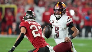 Washington Commanders quarterback Jayden Daniels (5) runs against Tampa Bay Buccaneers cornerback Zyon McCollum (27) during the first half of an NFL wild-card playoff football game in Tampa, Fla., Sunday, Jan. 12, 2025. (Chris O'Meara/AP)