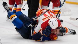 St. Louis Blues' Dylan Holloway, bottom, and Calgary Flames' Mikael Backlund (11) fight during the second period of an NHL hockey game Thursday, Jan. 16, 2025, in St. Louis. (Jeff Roberson/AP)