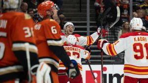 Calgary Flames centre Jonathan Huberdeau (10) celebrates his game-winning goal with right wing Matt Coronato (27) and center Nazem Kadri (91) during the overtime of an NHL hockey game against the Anaheim Ducks, Tuesday, Jan. 7, 2025, in Anaheim, Calif. (Kyusung Gong/AP)