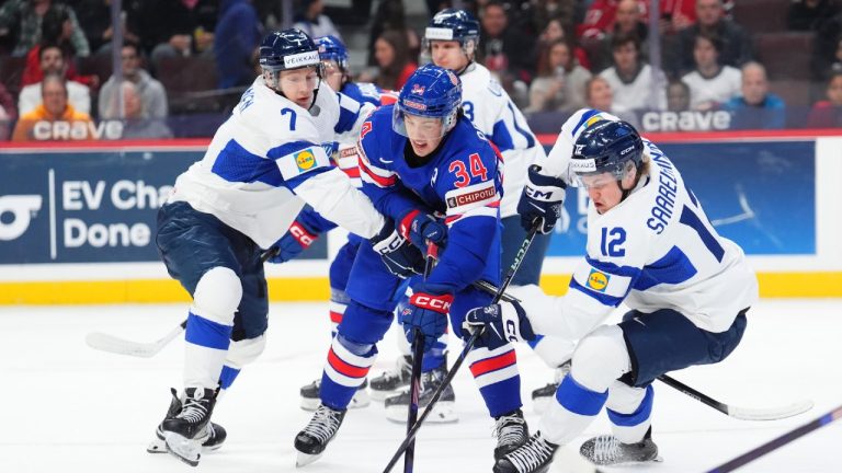 United States forward Gabe Perreault (34) skates with the puck as Finland forward Joona Saarelainen (12) and Daniel Nieminen (7) defend. (Sean Kilpatrick/CP)