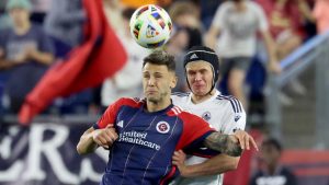 New England Revolution forward Giacomo Vrioni, left, and Vancouver Whitecaps defender Bjørn Inge Utvik, right, head the ball during the second half of an MLS soccer match. (Mark Stockwell/AP)