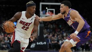 Miami Heat forward Jimmy Butler (22) drives on Phoenix Suns guard Devin Booker during the first half of an NBA basketball game, Wednesday, Nov. 6, 2024, in Phoenix. (Rick Scuteri/AP)