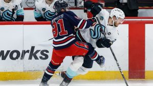 Winnipeg Jets' Cole Perfetti (91) and Seattle Kraken's Jamie Oleksiak (24) collide during first period NHL action in Winnipeg on Thursday, January 16, 2025. (John Woods/CP)