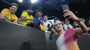 Joao Fonseca of Brazil takes a selfie with fans after defeating Andrey Rublev of Russia in their first round match at the Australian Open in Melbourne, Australia, Tuesday, Jan. 14, 2025. (AP Photo/Asanka Brendon Ratnayake)