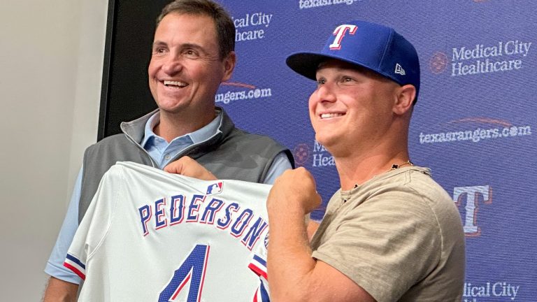 Texas Rangers president of baseball operations Chris Young, left, poses for photos with Joc Pederson during a news conference announcing Pederson's two-year contract with the team, Monday, Dec. 30, 2024, in Arlington, Texas. (AP Photo/Stephen Hawkins)