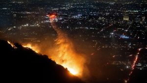 Water is dropped by helicopter on the burning Sunset Fire in the Hollywood Hills section of Los Angeles, Wednesday, Jan. 8, 2025. (Ethan Swope/AP)