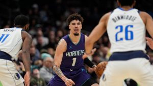 Charlotte Hornets guard LaMelo Ball (1) handles the ball against Dallas Mavericks guard Kyrie Irving (11) and guard Spencer Dinwiddie (26) during the first half of an NBA basketball game. (Jim Dedmon/AP)